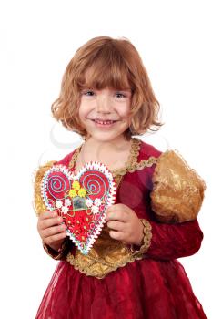 beautiful little girl holding gingerbread heart 
