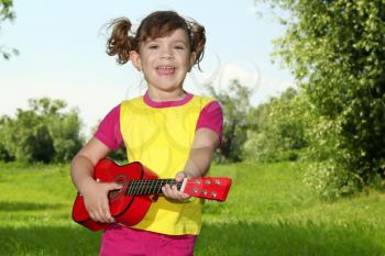 happy little girl play guitar and sing