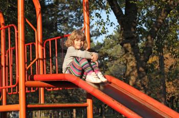 little girl sitting on slide
