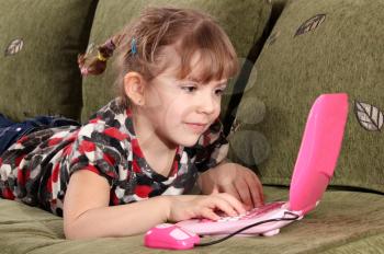little girl typing on laptop