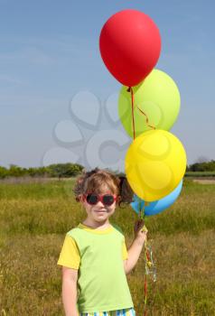 little girl with colorful balloons posing