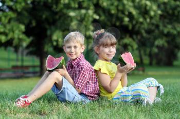 boy and little girl eat watermelon