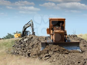 bulldozer and excavator on road construction