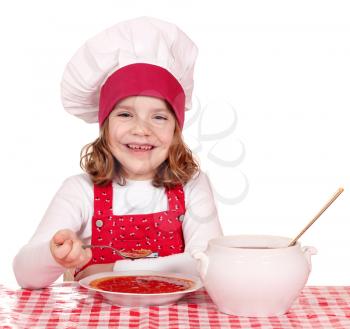 happy little girl cook eating soup