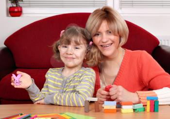 happy mother and daughter play with plasticine