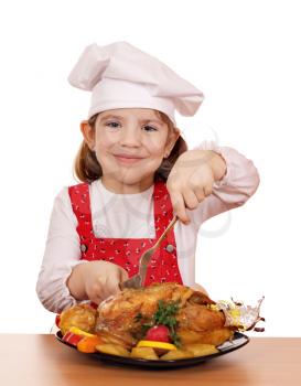 little girl cook cutting roast chicken