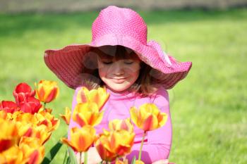 little girl and tulip flowers garden