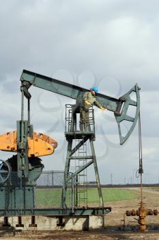 oilfield with worker and pump jack