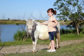 happy little girl with pony horse
