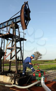 oil worker with pipe wrench and pipeline