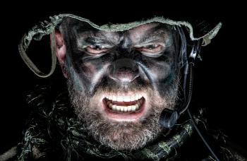 United States Commando face studio shot. Mouth opened, soldier yelling, emitting intimidate formidable frightening scream. Closeup portrait, cropped, isolated, bottom light