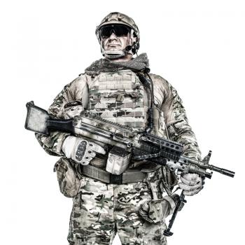 Half length low angle studio shot of big muscular soldier in field uniforms with machine gun, portrait isolated on white background lot of copyspace. Protective goggles glasses are on