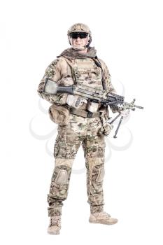 Full length low angle studio shot of big muscular soldier in field uniforms with machine gun, portrait isolated on white background lot of copyspace. Protective goggles glasses are on