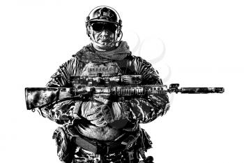 Half length cropped studio shot of big muscular soldier in field uniforms with sniper rifle, portrait isolated on white background lot of copyspace. Protective goggles glasses are on