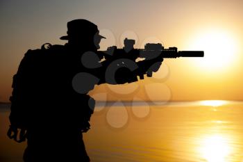 Army soldier with rifle orange sunset silhouette