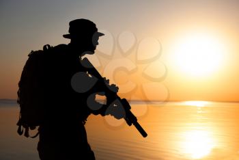 Army soldier with rifle orange sunset silhouette