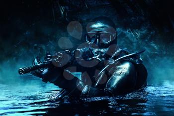 Combat diver of special forces operations unit frogmen comes up in jungle in diving gear. Dark night, moonlight, diversionary operation with weapon