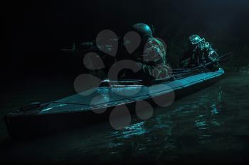 Two special forces soldiers in the military kayak. Diversionary mission under cover of darkness