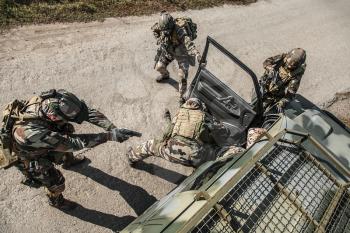 Squad of elite french paratroopers of 1st Marine Infantry Parachute Regiment RPIMA detaining terrorist in the car, top view from above