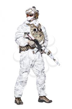 Special forces operator of Navy Seals armed with assault rifle with closed face in polarized sunglasses and military winter camo clothes turning back. Studio shot