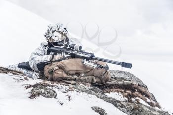 Army soldier with Sniper rifle in action in the Arctic. He lies among the cold rocks and stones, almost freezing to death, but waiting as long as enemies appear to kill them. Duty, service and loyalty