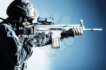 Army soldier in Protective Combat Uniform holding Special Operations Forces Combat Assault Rifle. Shooting weapon close up. Studio shot, isolated on white background