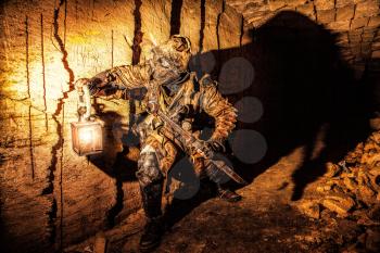 Underground post apocalyptic creature with homemade weapons and lantern