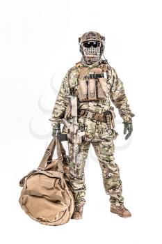 Soldier standing with duffel bag studio shot
