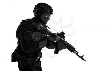 Studio portrait of police special forces member, quick reaction group shooter in black uniforms, helmet, hidden behind mask and glasses face, armed with assault rifle isolated on white, copyspace