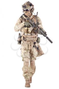 Strikeball enthusiast in checkered shirt wearing military ammunition, face mask, helmet and radio headset, tactical glasses, camo pants, armed service rifle and handgun studio shoot isolated on white