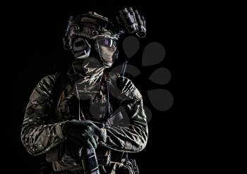 US marine riders shooter, army special forces soldier standing in darkness in mask, battle uniform, quad-tube, four lenses night vision goggles on helmet, low key, side view, studio portrait on black