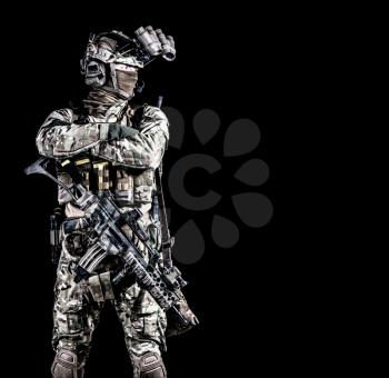 Modern combatant, army special forces soldier, counter terrorist squad mender in full ammunition, hiding face behind mask, equipped night vision device, standing with arms crossed on chest, copyspace