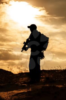 private military contractor with rifle against the sun