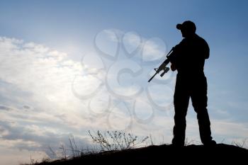 private military contractor with rifle against the sun