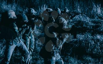 Two soldiers, special forces fighters, border guards team, counter-terrorism tactical group shooters aiming rifles, stopping offenders, attacking enemies during night patrolling, at sabotage mission