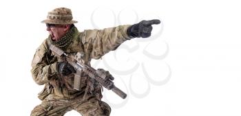 Army soldier, special operations fighter in combat uniform, armed service rifle, pointing with finger straight ahead, yelling and showing attack direction, commander screaming order to comrades