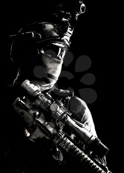Shoulder portrait of army elite troops sniper, anti-terrorist tactical team marksman wearing helmet with thermal imager, hiding face behind mask, armed rifle with optical scope, studio shoot on black