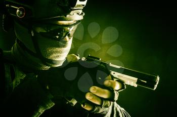 Army counter-terrorism squad, police SWAT team fighter hiding identity behind mask and glasses, wearing helmet with night vision-device, creeping in darkness, aiming service pistol during mission