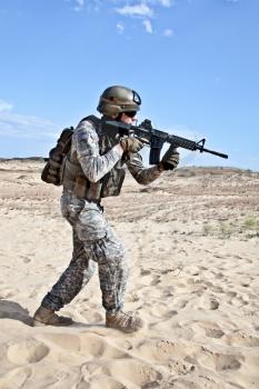 US soldier going through the desert during the military operation