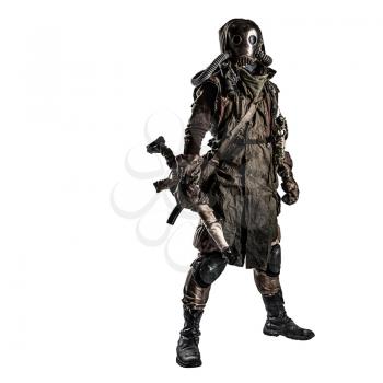 Survivor inhabitant of contaminated by nuclear catastrophe or dangerous chemical pollution world, in tatters and gas mask, standing with handmade firearm gun, isolated on white background studio shoot