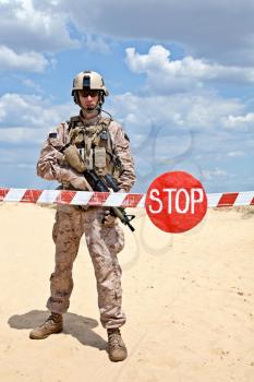 US marine with assault rifle near the barrier at a checkpoint