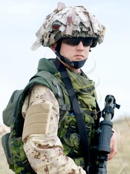 soldier in desert uniform holding his rifle