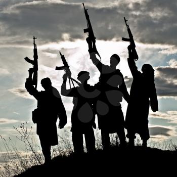 Silhouette of several muslim militants with rifles 