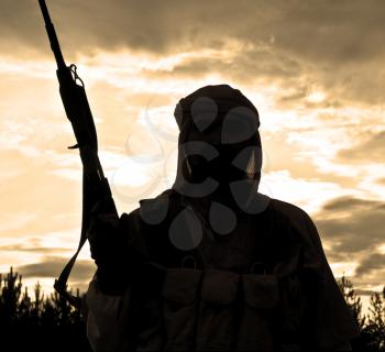 Silhouette of muslim rebel with rifle