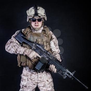 US marine with his assault rifle on black background