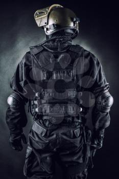 Spec ops soldier on black background shot from behind