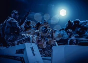 Commando fighters team, equipped and armed Navy SEALs soldiers on speed boat deck, preparing to secret mission or raid, patrolling coastline at night. Special forces shooters on boat at full moon
