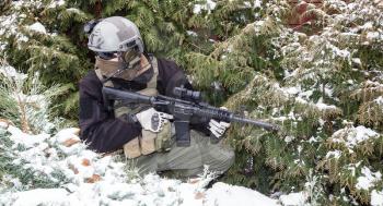 Private military contractor PMC with assault rifle in the winter forest