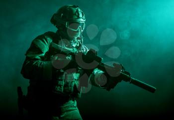 Special forces soldier with rifle in the smoke
