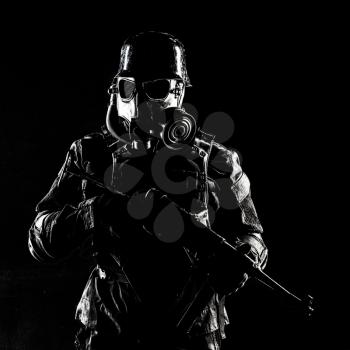 Futuristic nazi soldier gas mask and steel helmet with schmeisser handgun black background studio shot
